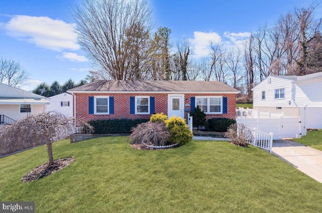ranch-style house with brick siding, fence, and a front yard