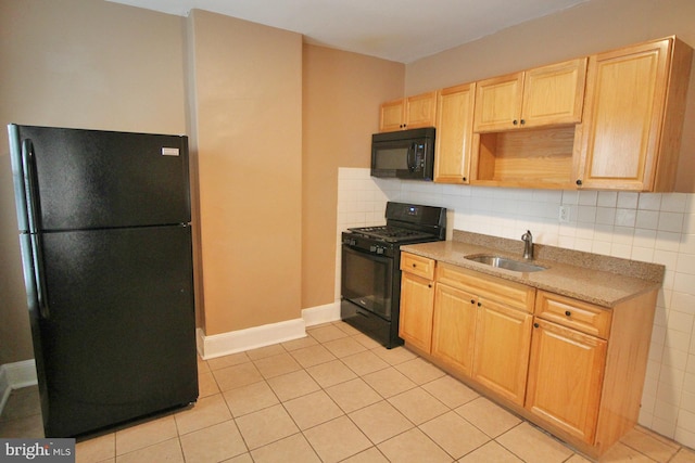 kitchen featuring decorative backsplash, light brown cabinets, a sink, light tile patterned floors, and black appliances