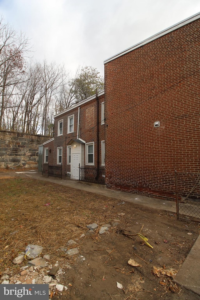 view of property exterior featuring a patio area and brick siding