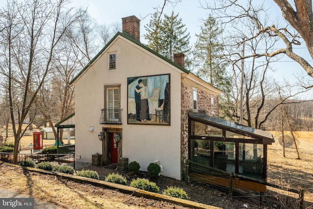 view of front of house with a chimney and stucco siding