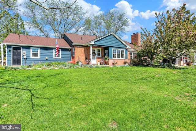 ranch-style house featuring brick siding, a chimney, and a front lawn