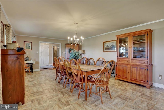 dining space with baseboards, ornamental molding, and a chandelier