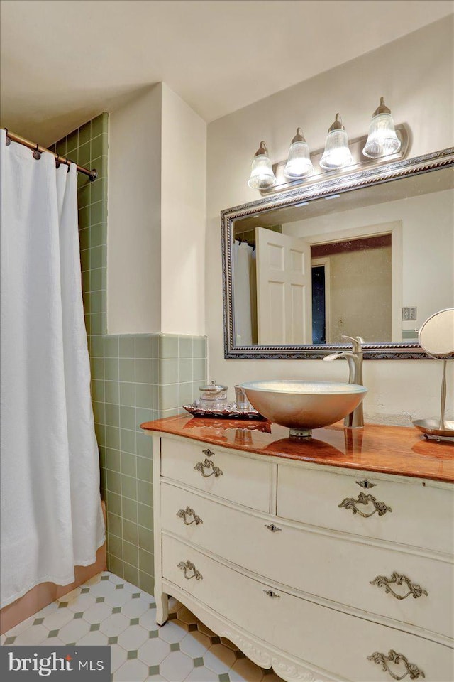 bathroom featuring tile walls, a shower with shower curtain, and vanity