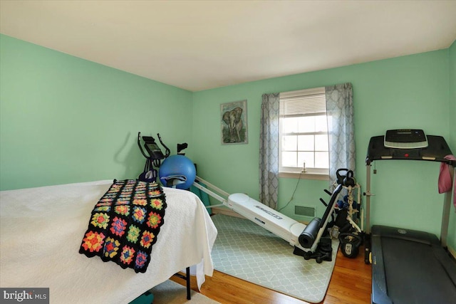 bedroom featuring wood finished floors and visible vents
