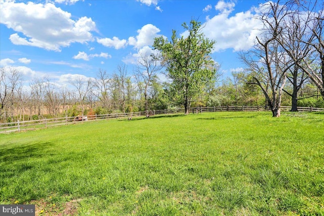 view of yard featuring fence and a rural view