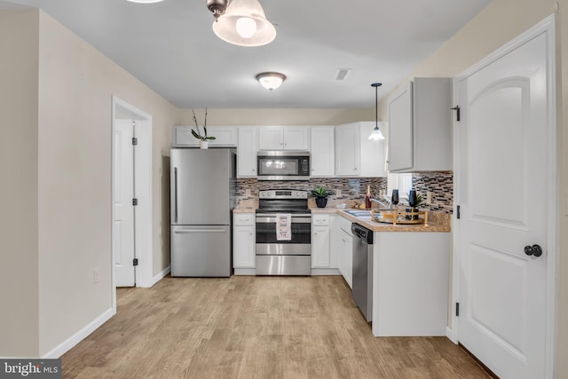 730 Farmwood Ln, Lebanon, PA 17042 - kitchen featuring stainless steel appliances, a sink, decorative backsplash, light countertops, and light wood finished floors