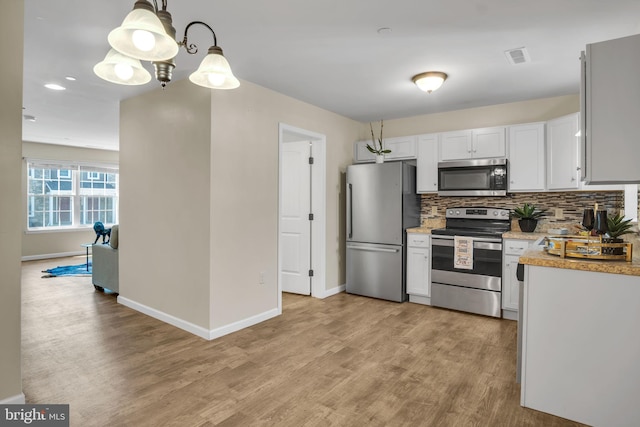730 Farmwood Ln, Lebanon, PA 17042 - kitchen with stainless steel appliances, light wood-style flooring, baseboards, decorative backsplash, and white cabinetry
