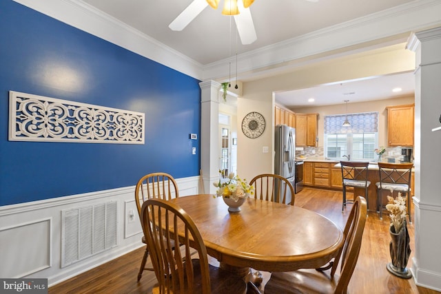 dining space with ceiling fan, a wainscoted wall, visible vents, and light wood-style floors