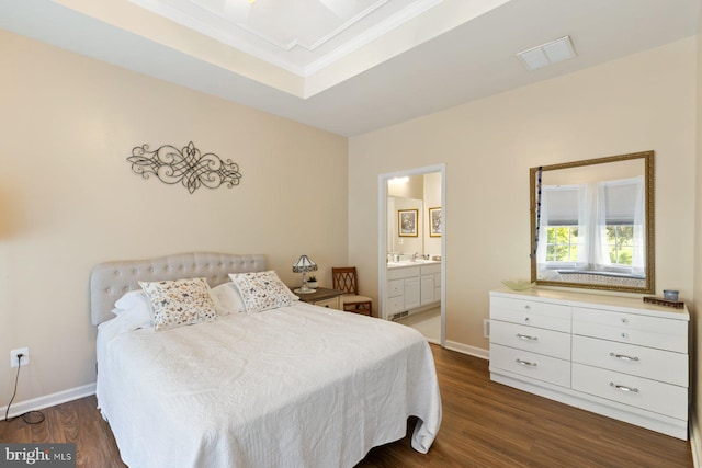 bedroom with ensuite bathroom, visible vents, baseboards, dark wood-type flooring, and ornamental molding