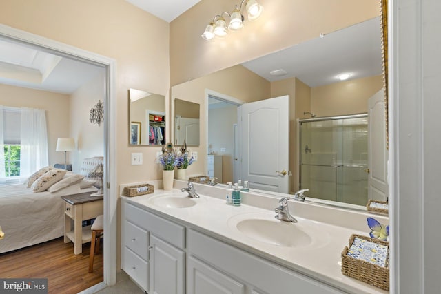 full bathroom with a stall shower, connected bathroom, double vanity, and a sink