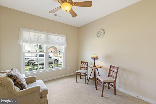 sitting room featuring baseboards, ceiling fan, light carpet, and visible vents