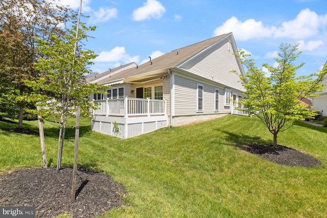 view of side of property featuring a deck and a lawn