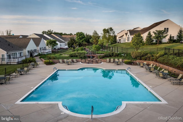 pool with fence, a patio, and a residential view