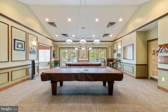 rec room with light colored carpet, vaulted ceiling, a decorative wall, and visible vents