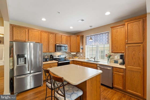 kitchen with light countertops, stainless steel appliances, tasteful backsplash, and a sink