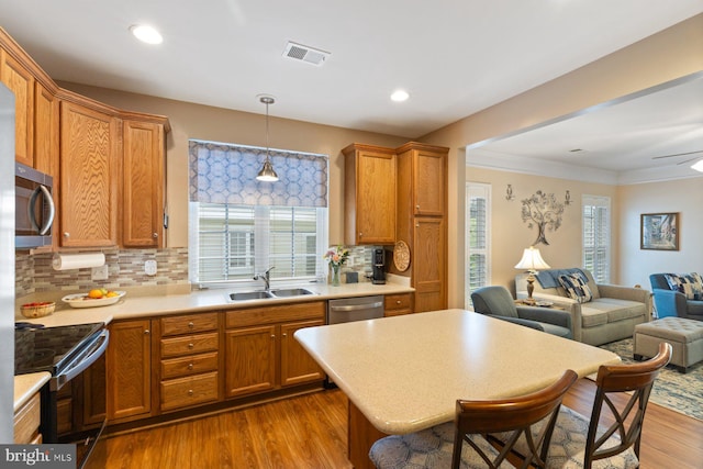 kitchen featuring a sink, dark wood-type flooring, visible vents, open floor plan, and appliances with stainless steel finishes
