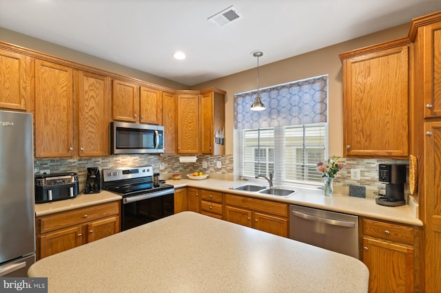 kitchen with a sink, stainless steel appliances, visible vents, decorative backsplash, and light countertops