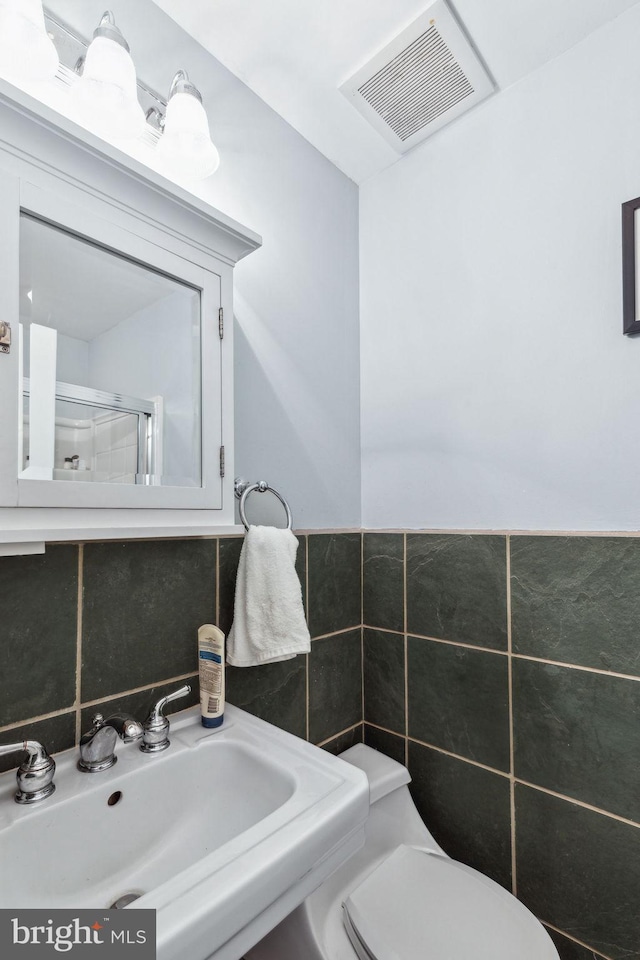 2308 Spruce St Unit 2310A, Philadelphia, PA 19103 - bathroom featuring visible vents, an enclosed shower, tile walls, a sink, and toilet