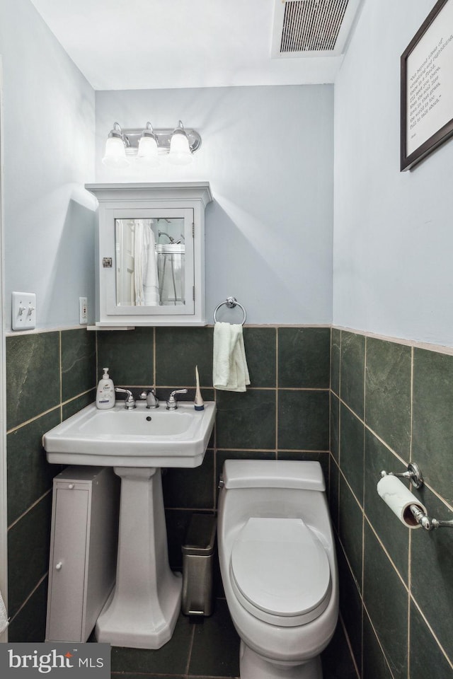 2308 Spruce St Unit 2310A, Philadelphia, PA 19103 - bathroom featuring visible vents, wainscoting, toilet, tile walls, and a sink