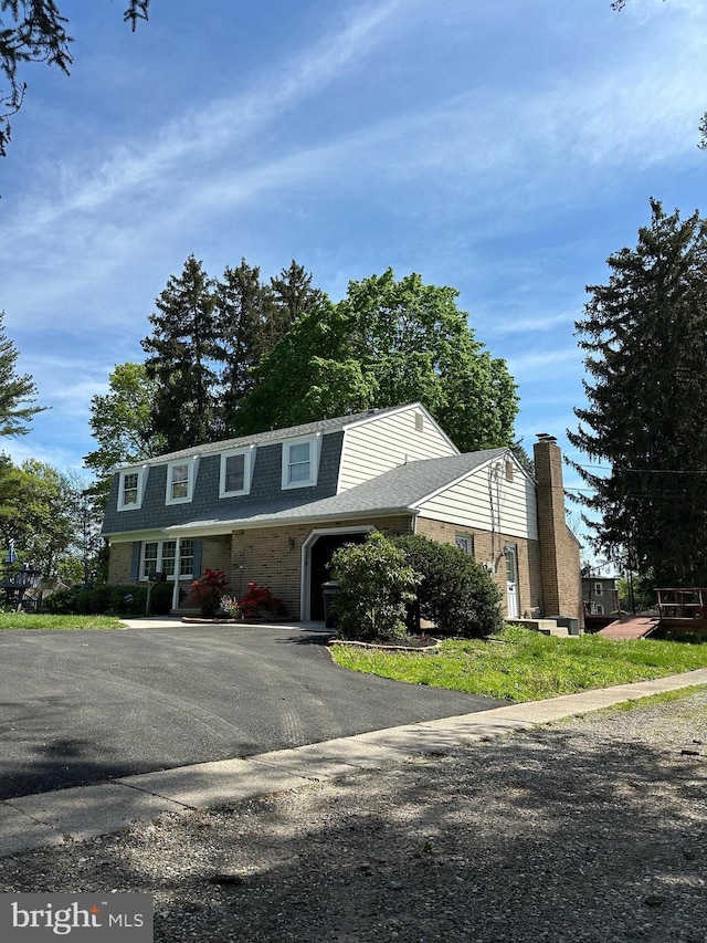 755 Shawmont Ave, Philadelphia, PA 19128 - view of front of home featuring a chimney, roof with shingles, a garage, and driveway