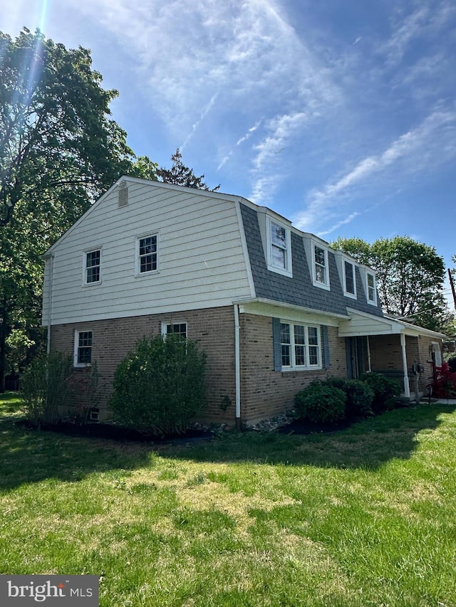 755 Shawmont Ave, Philadelphia, PA 19128 - view of property exterior featuring brick siding, a yard, roof with shingles, and mansard roof