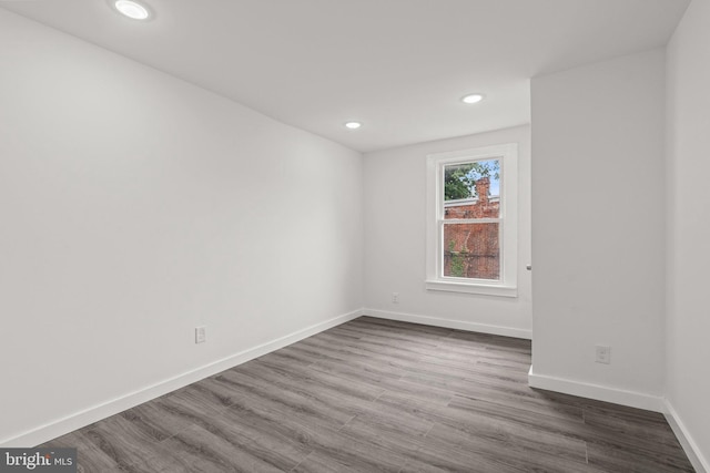empty room with baseboards, dark wood-style floors, and recessed lighting