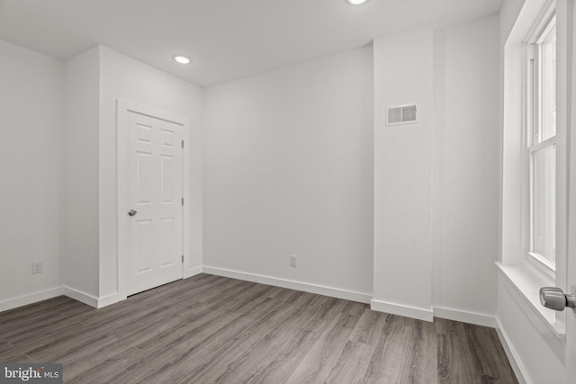 spare room featuring visible vents, wood finished floors, baseboards, and recessed lighting