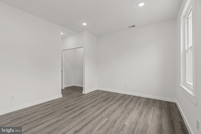 unfurnished room with recessed lighting, baseboards, visible vents, and wood finished floors