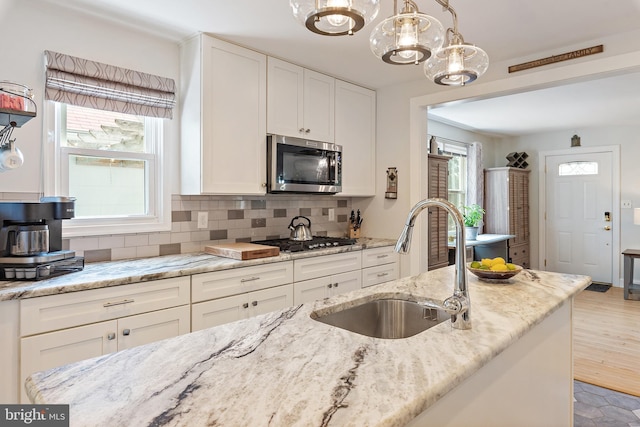 111 Linden Ave, Pasadena, MD 21122 - kitchen featuring a sink, white cabinets, a chandelier, and stainless steel appliances