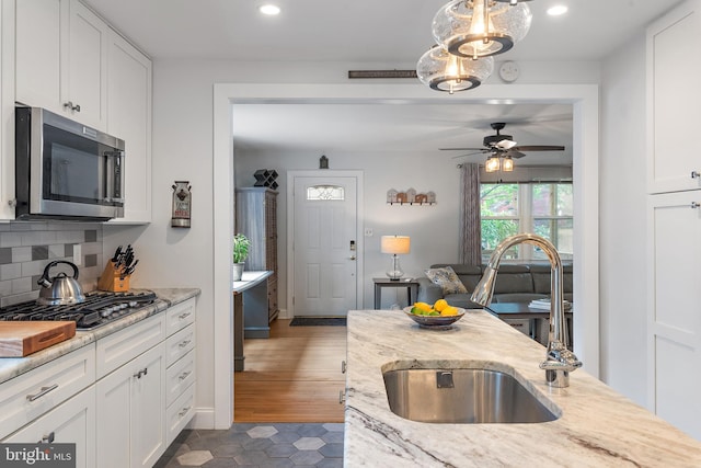 111 Linden Ave, Pasadena, MD 21122 - kitchen with white cabinets, a ceiling fan, appliances with stainless steel finishes, and a sink