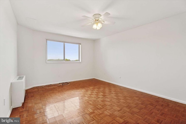 spare room featuring radiator heating unit, baseboards, and a ceiling fan