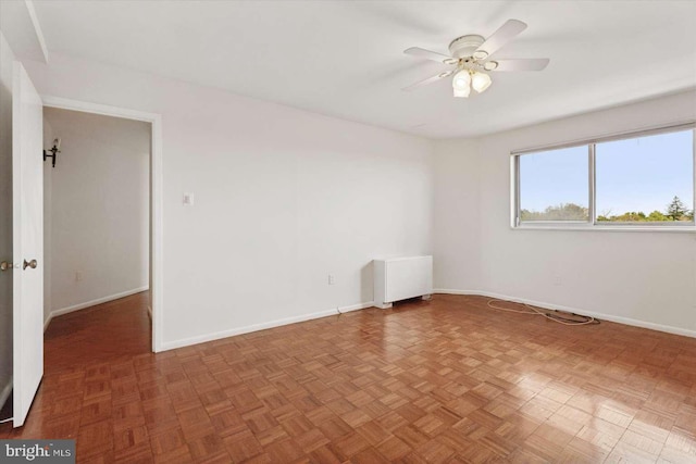 unfurnished room featuring ceiling fan and baseboards