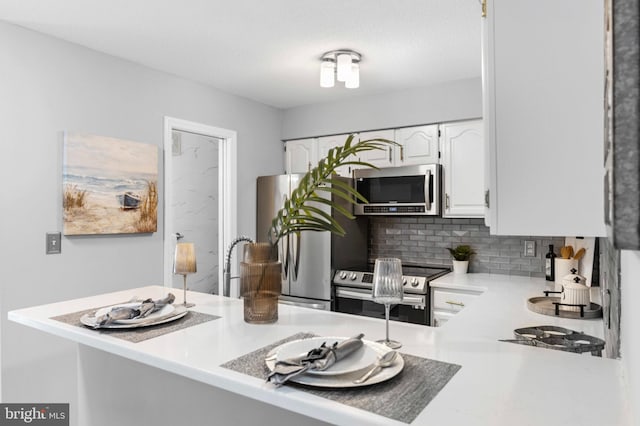 kitchen featuring white cabinets, stainless steel appliances, light countertops, and tasteful backsplash