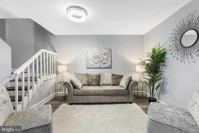 living area featuring stairs, baseboards, and wood finished floors