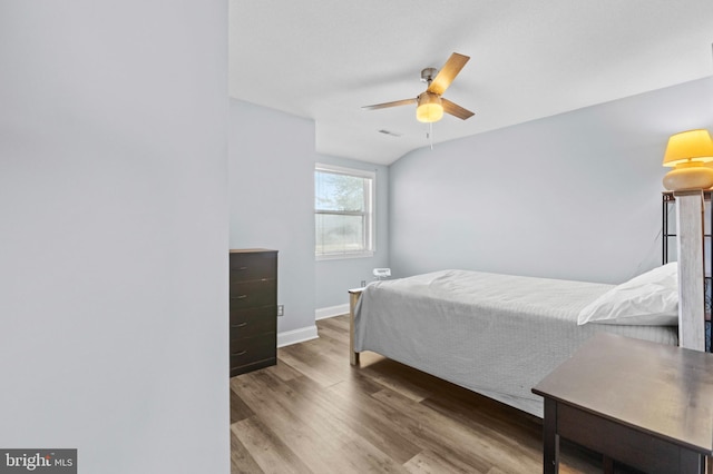 bedroom with ceiling fan, baseboards, visible vents, and wood finished floors
