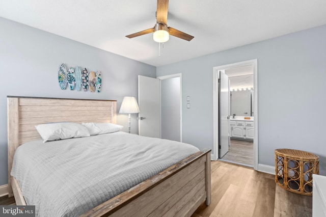 bedroom with baseboards, ceiling fan, light wood-type flooring, and ensuite bath
