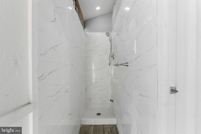 bathroom featuring a marble finish shower and wood finished floors