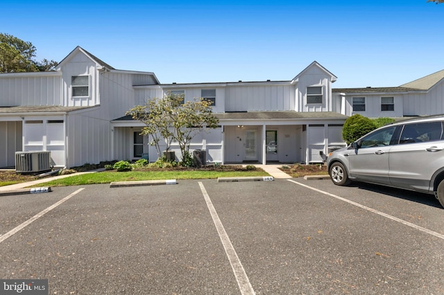 view of front of home with uncovered parking and central AC unit