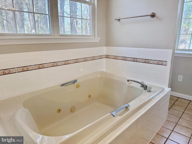 bathroom with tile patterned flooring and a jetted tub