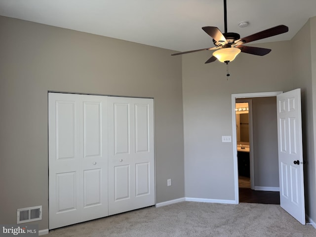 unfurnished bedroom with carpet floors, baseboards, visible vents, and a closet