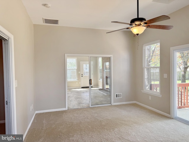 unfurnished room with ceiling fan, visible vents, baseboards, and carpet