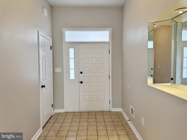 foyer with visible vents, baseboards, and light tile patterned flooring