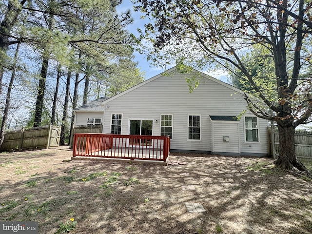 rear view of house featuring a fenced backyard and a wooden deck