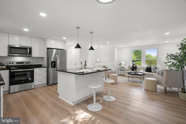 3604 Ripplingbrook Ct, Bowie, MD 20721 - kitchen with dark countertops, open floor plan, white cabinetry, light wood finished floors, and appliances with stainless steel finishes