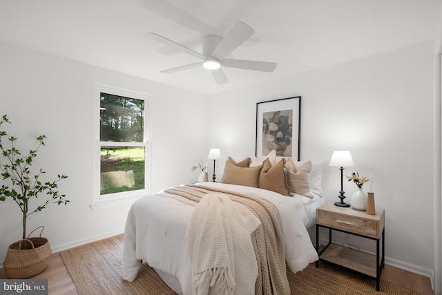 bedroom with baseboards, ceiling fan, and wood finished floors