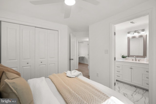 bedroom featuring connected bathroom, visible vents, a sink, a closet, and marble finish floor