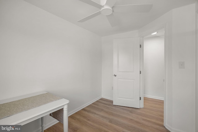 interior space with a ceiling fan, baseboards, and light wood finished floors
