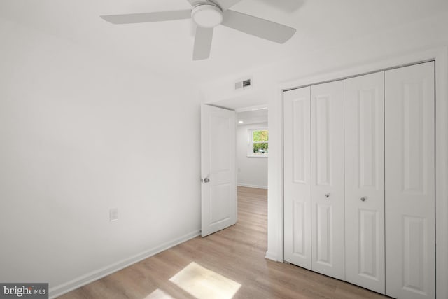 unfurnished bedroom with visible vents, a closet, light wood-style floors, baseboards, and a ceiling fan