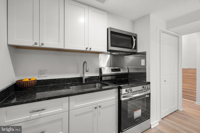 3604 Ripplingbrook Ct, Bowie, MD 20721 - kitchen featuring a sink, white cabinets, light wood-style floors, dark stone counters, and stainless steel appliances