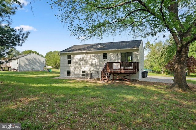 back of property with a lawn, a wooden deck, and stairs